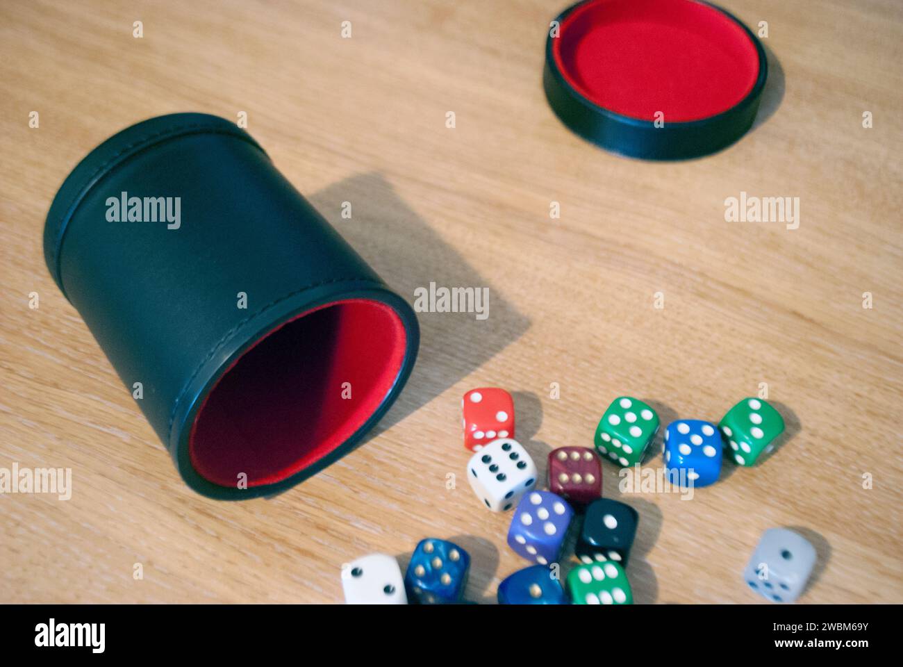 Dice spilling from black dice cup Stock Photo
