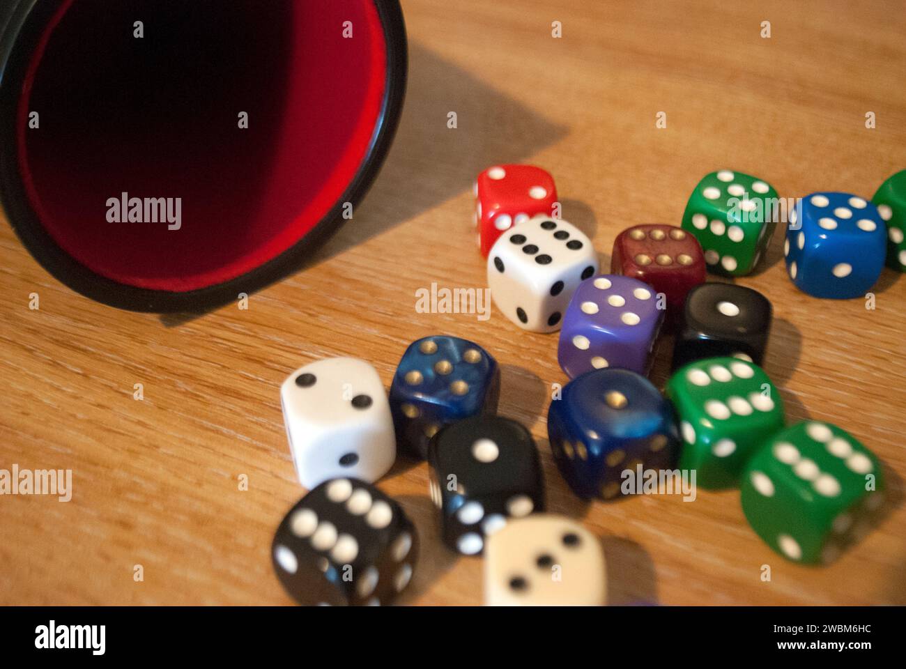 Dice spilling from black dice cup Stock Photo