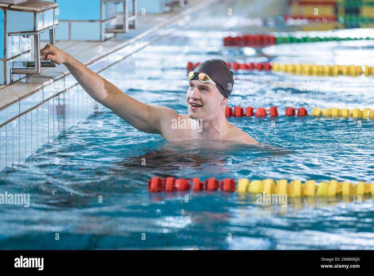 Man swimmer happy at the finish of a race in the pool at competition ...
