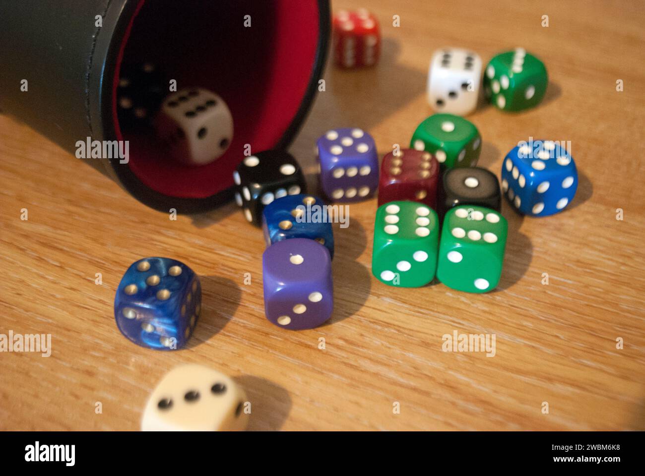 Dice spilling from black dice cup Stock Photo