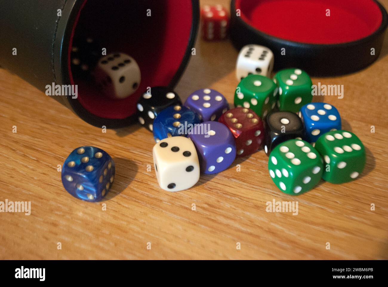 Dice spilling from black dice cup Stock Photo