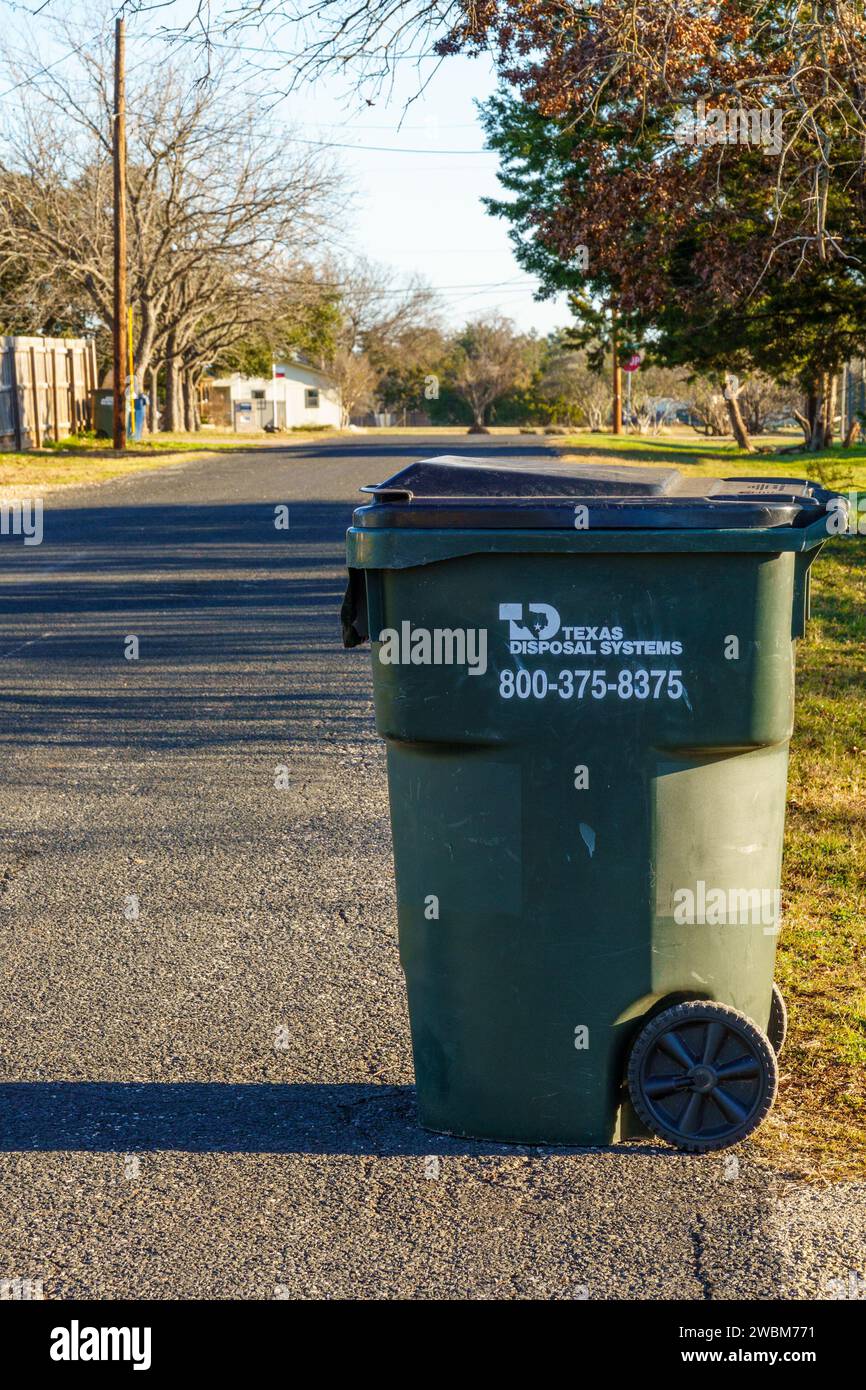 Residential garbage bin waiting by street for pickup by city refuse collection truck Stock Photo