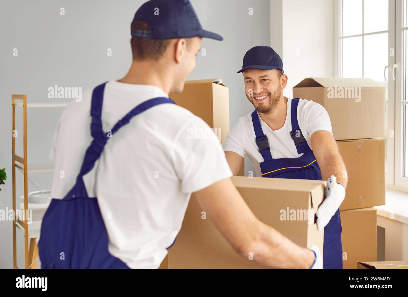 Two Movers Working on Home or Office Move with Cardboard Boxes Stock Photo