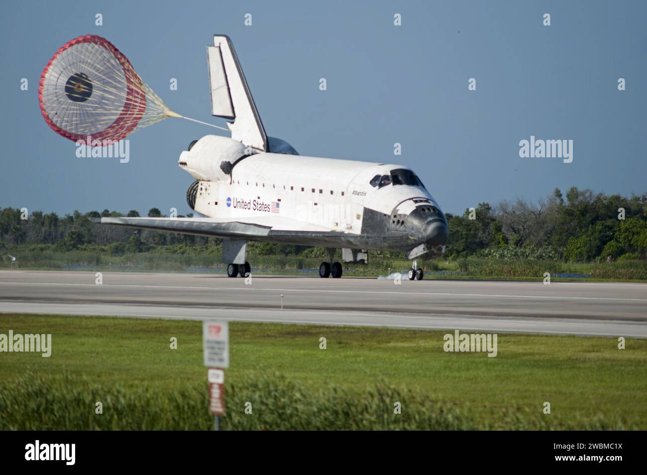 Space shuttle Atlantis deploys its drag chute while rolling to a stop ...