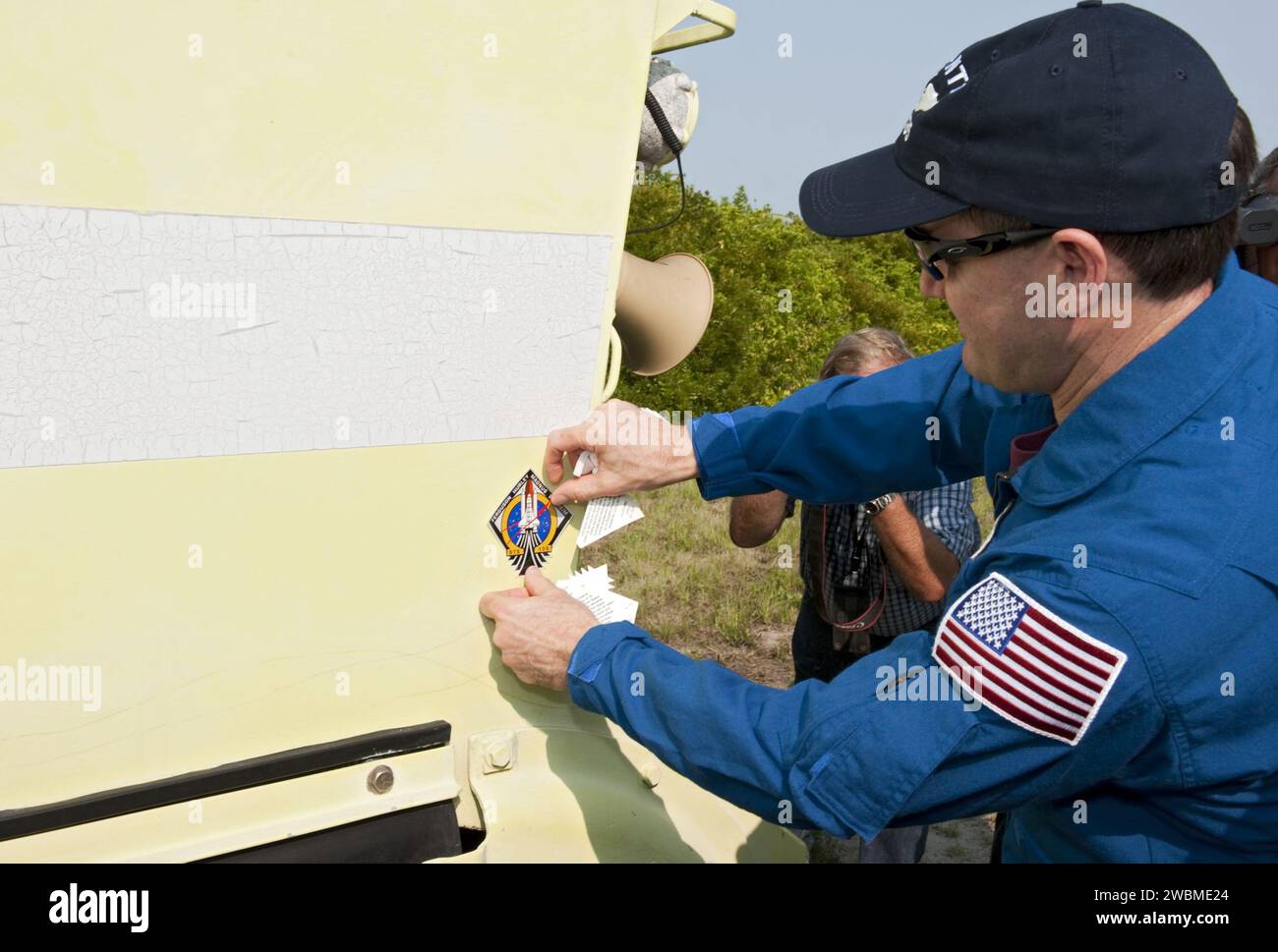 CAPE CANAVERAL, Fla. -- Mission Specialist Rex Walheim affixes his mission's logo on an M113 armored personnel carrier during training at NASA's Kennedy Space Center in Florida . It's tradition for crew members during TCDT to put their mission logo sticker on the M113 they train in. An M113 is kept at the foot of the launch pad in case an emergency exit from the launch pad is needed and every shuttle crew is trained on driving the vehicle before launch. The crew is at Kennedy to participate in a launch countdown dress rehearsal called the Terminal Countdown Demonstration Test (TCDT) and relate Stock Photo