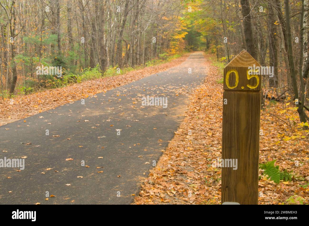 Rail trail with mile post, Windham Rail Trail, New Hampshire Stock