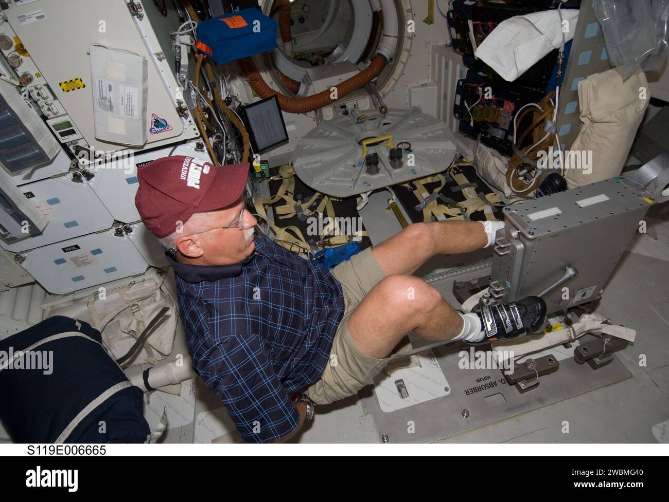 S119-E-006665 (19 March 2009) --- Astronaut John Phillips, STS-119 mission specialist, exercises on a bicycle ergometer on the middeck of Space Shuttle Discovery while docked with the International Space Station. Stock Photo