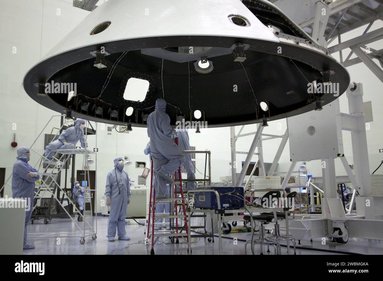 Technicians at Kennedy Space Center prepare the backshell, including ...