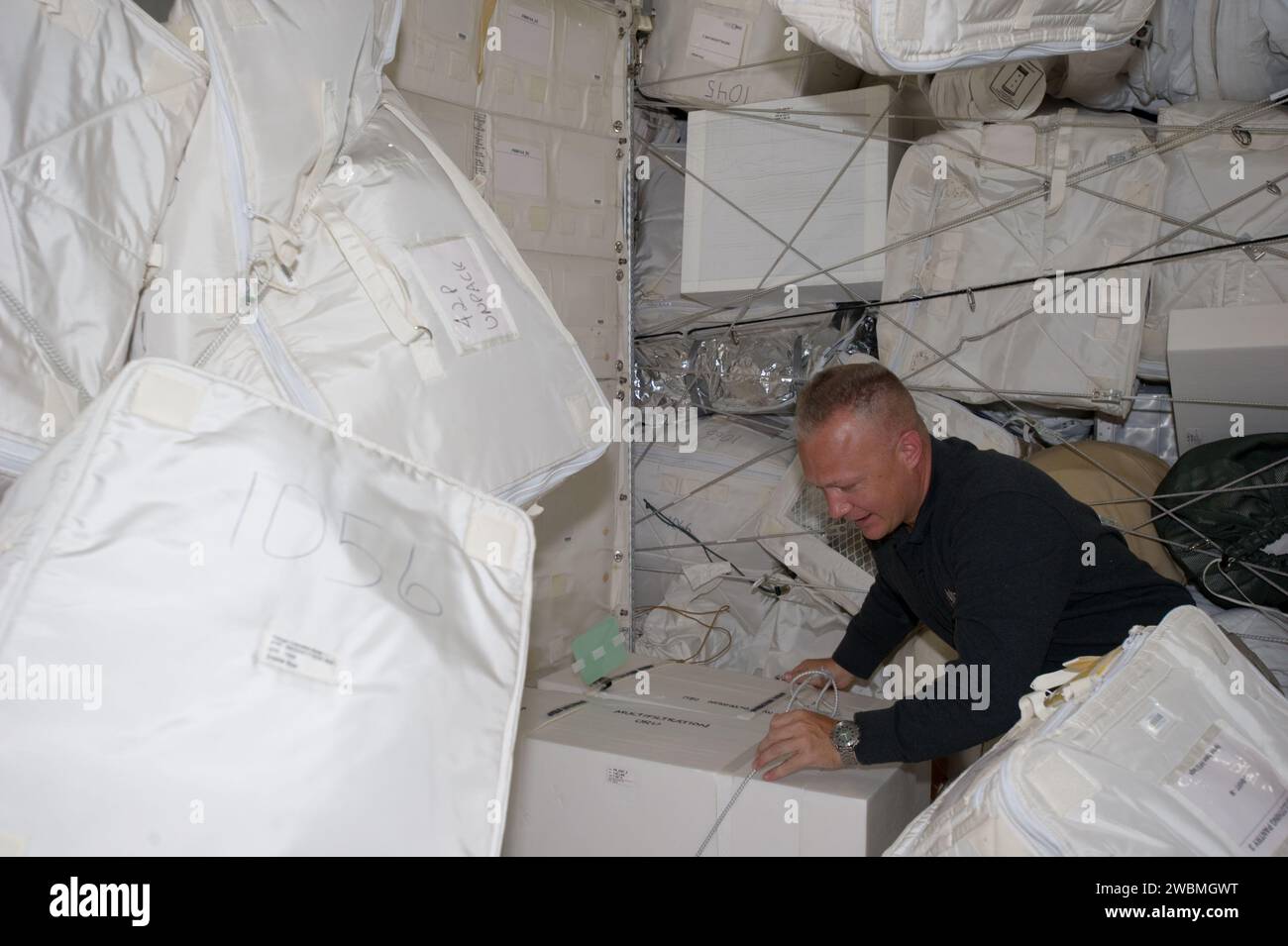 S135-E-007441 (11 July 2011) --- NASA astronaut Doug Hurley, STS-135 pilot, moves around supplies and equipment in the Leonardo Permanent Multipurpose Module (PMM) during the fourth day of flight for Atlantis' four person crew. This module is a component that joined the International Space Station complex after it was flown into space aboard the space shuttle Discovery on STS-133. Stock Photo