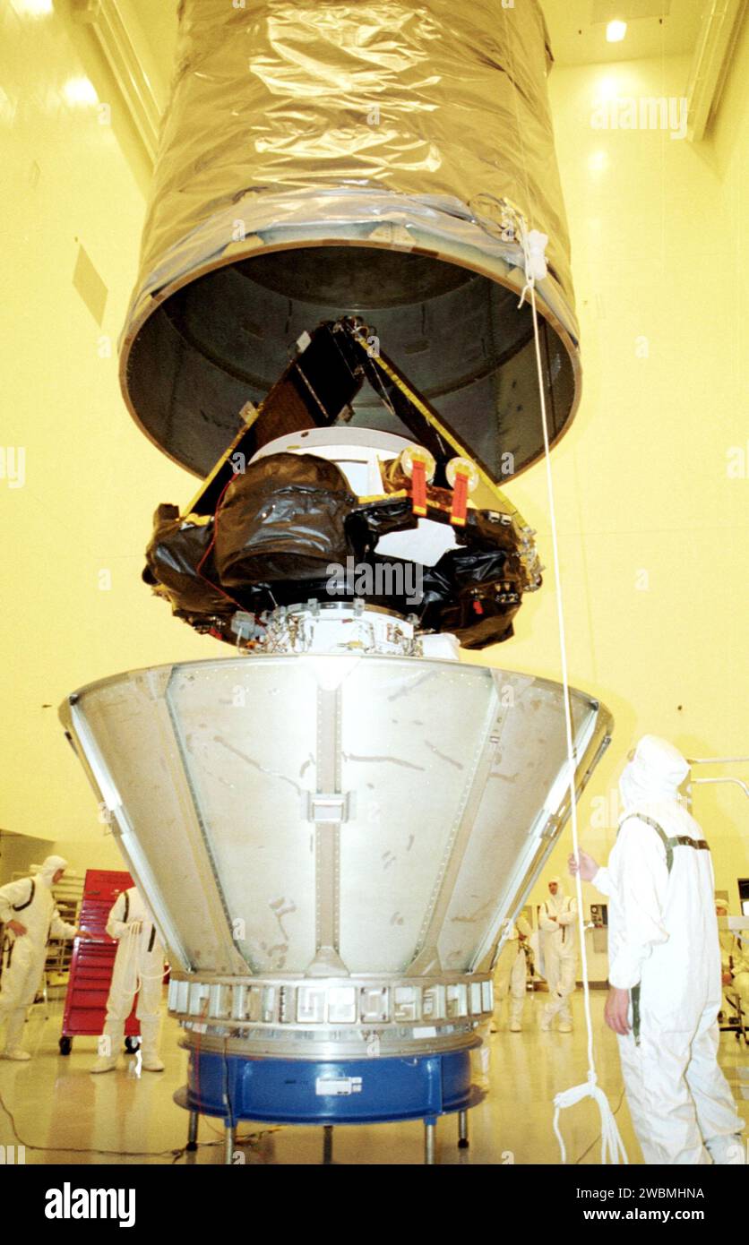 KENNEDY SPACE CENTER, Fla. -- In the Payload Hazardous Servicing Facility, workers help guide a transportation canister over the Genesis spacecraft in preparation for its move to the pad. Genesis is 7.5 feet (2.3 meters) long and 6.6 feet (2 meters) wide, with a wingspan of solar array 26 feet (7.9 meters) tip to tip. Genesis will be on a robotic NASA space mission to catch a wisp of the raw material of the Sun and return it to Earth with a spectacular mid-air helicopter capture. The sample return capsule is 4.9 feet (1.5 meters) in diameter and 52 inches (1.31 meters) tall. The mission’s goal Stock Photo