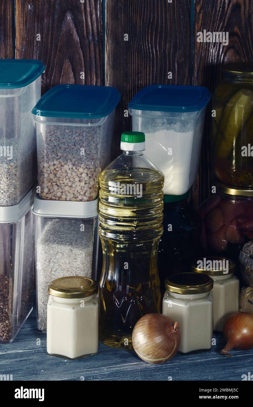 Food supplies for the period of quarantine isolation. Various glass jars with cereals, pasta, cans of canned food. Stock Photo