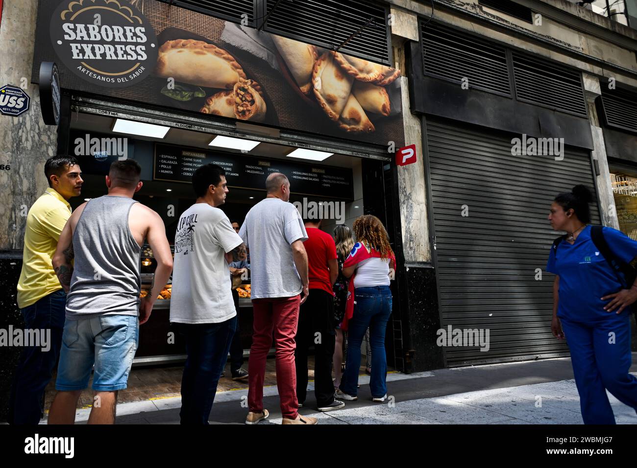 Buenos Aires, Argentina. 10th Jan, 2024. People stand in front of a meat doughnut shop with particularly low prices. The annual inflation rate in the South American country has risen to 211.4 percent. In December alone, prices rose by 25.5 percent. Credit: Martin Cossarini//dpa/Alamy Live News Stock Photo