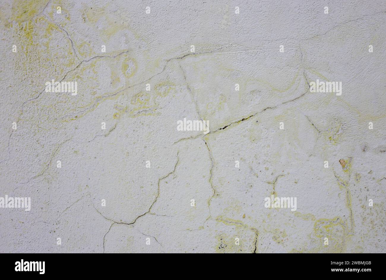Frosty yellow old paint on a gray wall. Stock Photo