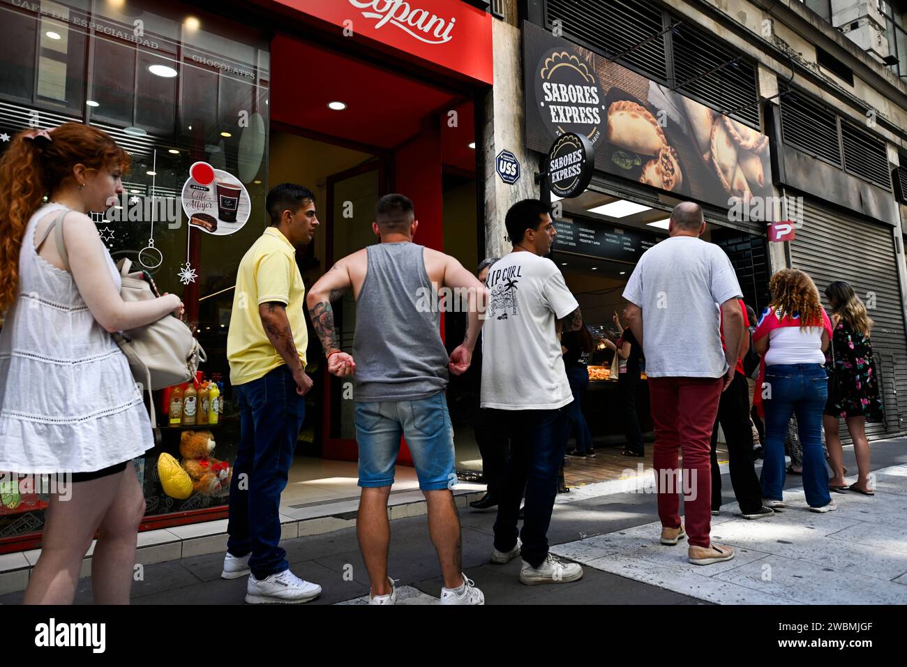 Buenos Aires, Argentina. 10th Jan, 2024. People stand in front of a meat doughnut shop with particularly low prices. The annual inflation rate in the South American country has risen to 211.4 percent. In December alone, prices rose by 25.5 percent. Credit: Martin Cossarini//dpa/Alamy Live News Stock Photo