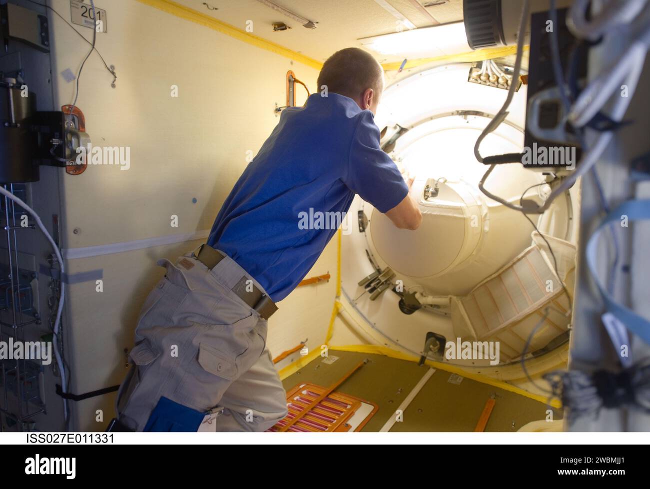 ISS027-E-011331 (6 April 2011) --- Russian cosmonaut Dmitry Kondratyev, Expedition 27 commander, prepares to open the Poisk Mini-Research Module 2 (MRM2) hatch to welcome NASA astronaut Ron Garan, along with Russian cosmonauts Andrey Borisenko and Alexander Samokutyaev, all flight engineers, to the International Space Station. The Soyuz TMA-21 docked to the MRM2 at 7:09 p.m. (EDT) on April 6, 2011. Stock Photo