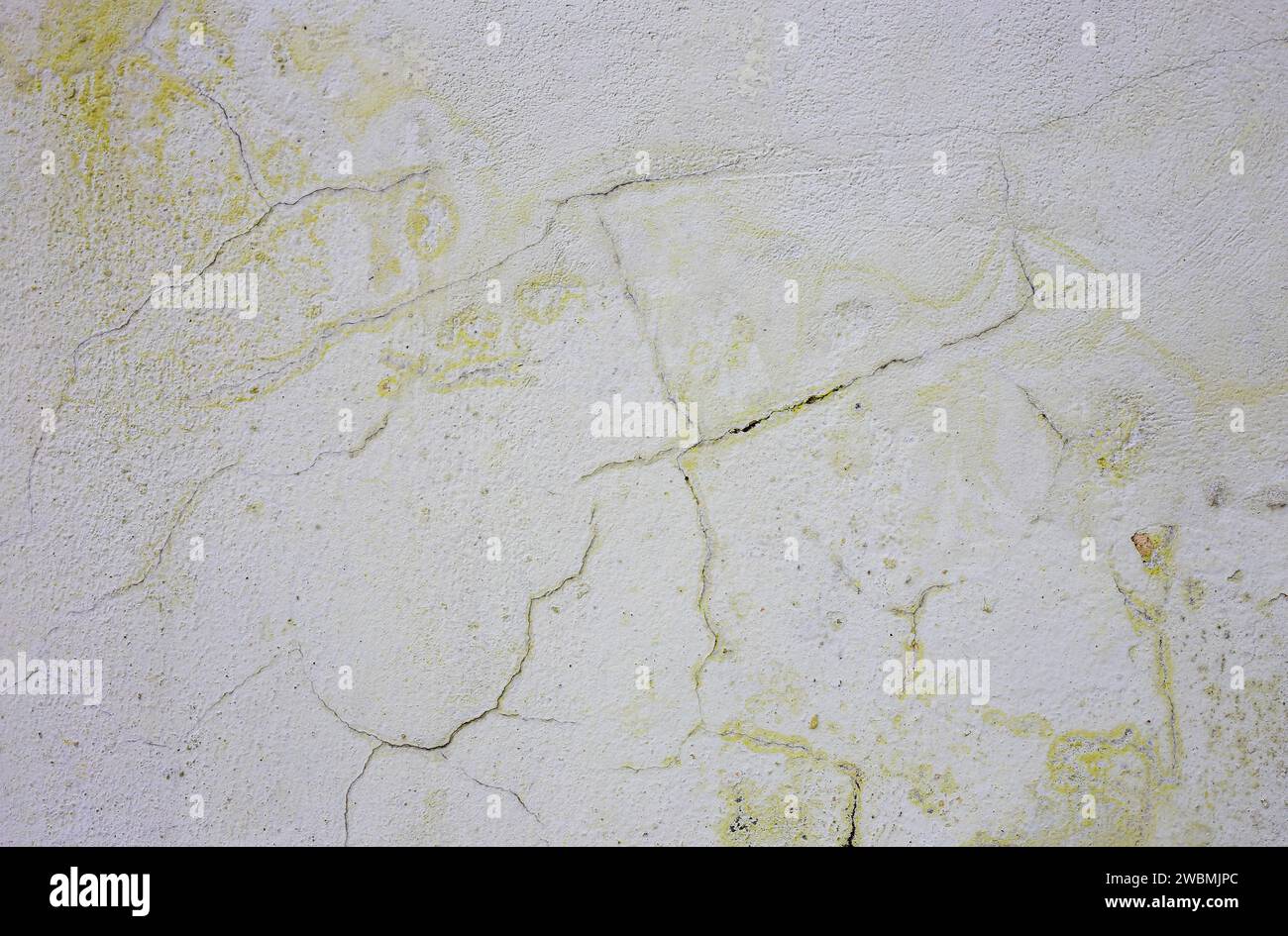 Frosty yellow old paint on a gray wall. Stock Photo