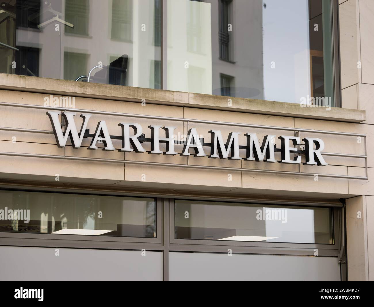 Warhammer logo sign on a store building facade. The shop sells small figures for collectors. The miniature wargame is popular around the world. Stock Photo