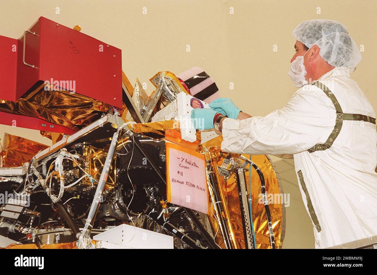 In the Spacecraft Assembly and Encapsulation Facility 2 (SAEF-2), a worker removes the High Energy Neutron Detector (HEND), part of the Gamma Ray Spectrometer (GRS), from the 2001 Mars Odyssey Orbiter. The HEND was built by Russia’s Space Research Institute (IKI). The GRS will achieve global mapping of the elemental composition of the surface and determine the abundance of hydrogen in the shallow subsurface. The orbiter will carry two other science instruments THEMIS and the Mars Radiation Environment Experiment (MARIE). THEMIS will map the mineralogy and morphology of the Martian surface usin Stock Photo