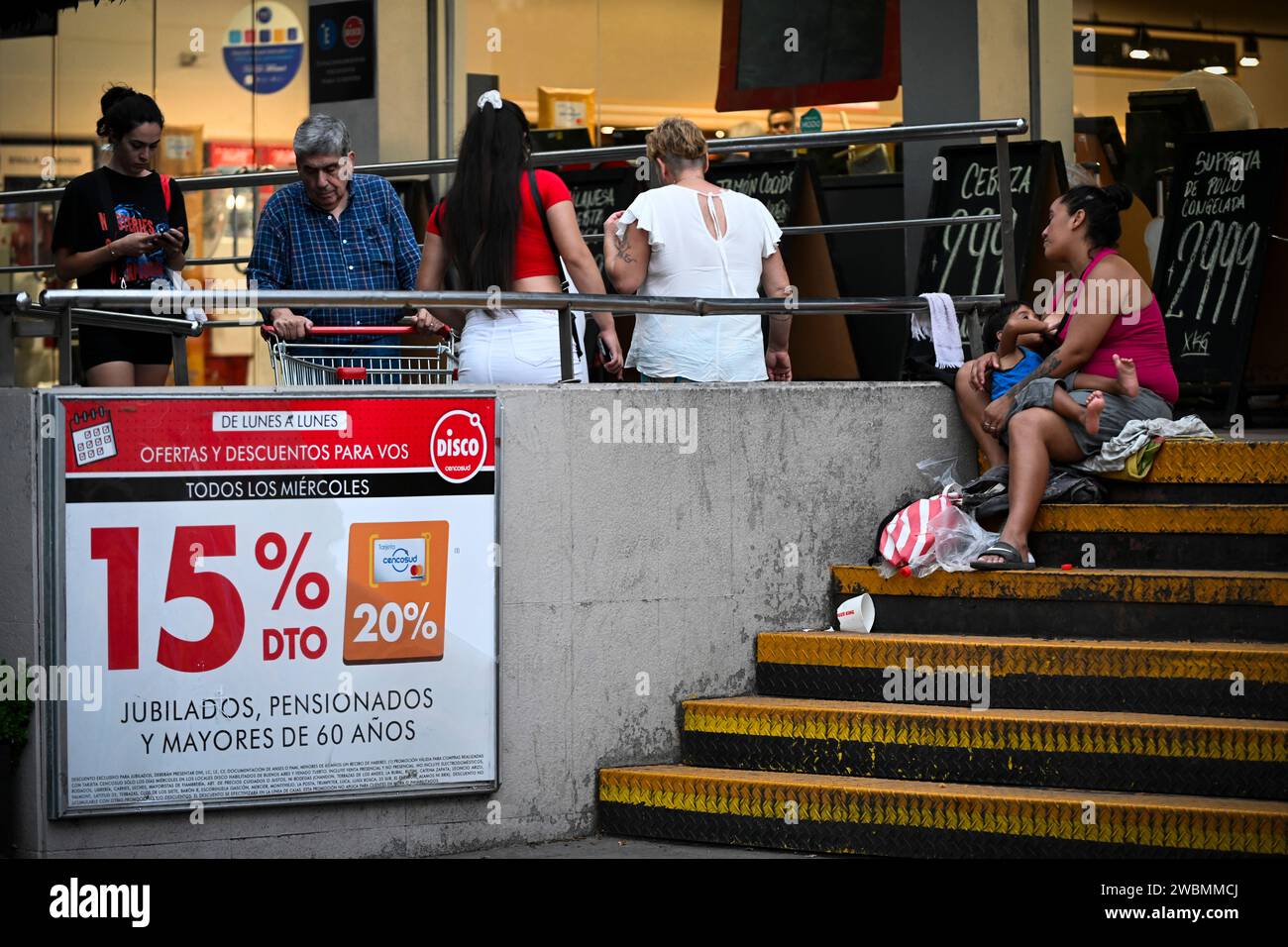 Buenos Aires Argentina 10th Jan 2024 A Woman With A Child In Her   Buenos Aires Argentina 10th Jan 2024 A Woman With A Child In Her Arms Asks For Donations At The Entrance To A Supermarket Food Prices Rose By 20 Percent In The Argentinian Capital In December 2023 Credit Martin Cossarinidpaalamy Live News 2WBMMCJ 