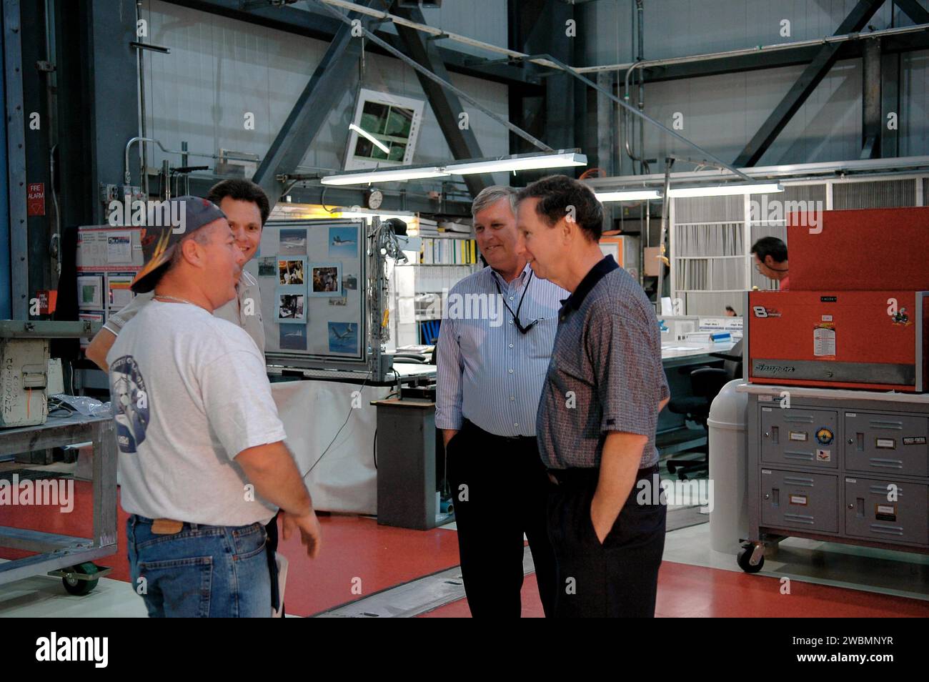 KENNEDY SPACE CENTER, FLA. - Michael Griffin, administrator of the National Aeronautics and Space Administration (NASA), talks to United Space Alliance advanced systems technician Richard Van Wart during a tour of Orbiter Processing Facility bay 1. From left are Van Wart, Space Shuttle Atlantis vehicle manager Scott Thurston, Center Director James Kennedy, and Griffin. Space Shuttle Atlantis is being processed for the second Return to Flight mission, STS-121, in the facility. This is Griffin's first official visit to Kennedy Space Center. Griffin is the 11th administrator of NASA, a role he as Stock Photo