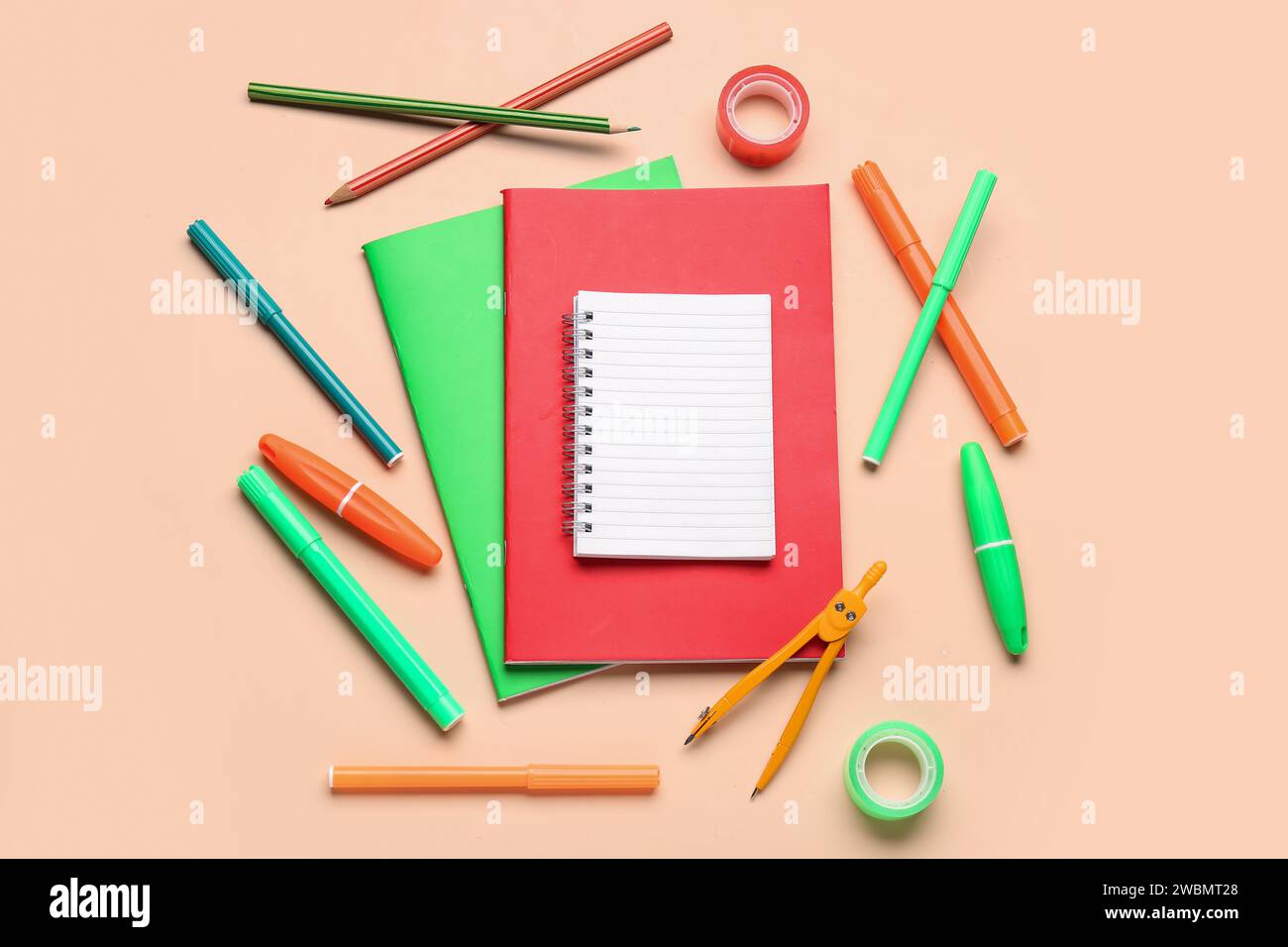 Notebooks with different stationery on pale orange background Stock Photo