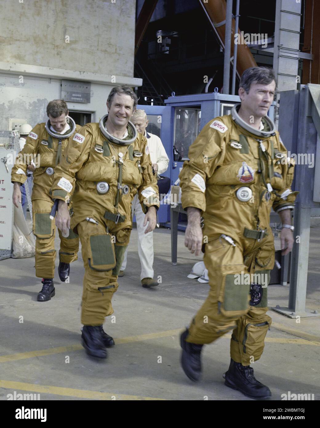 KENNEDY SPACE CENTER, FLA. - Space Shuttle prime and backup astronaut crews are preparing to be briefed on the use of the emergency pad escape system, known as the “slidewire”. From left to right are backup astronauts Joe Engle and Richard Truly, and primary crew Commander John Young. Both the prime and backup crews wore the spacesuits and other equipment they will wear during a mission. The slidewire system provides a quick and sure escape from the upper pad platforms in case of a serious emergency. The flight crews wore the spacesuits and other equipment to be worn during a mission, but sand Stock Photo