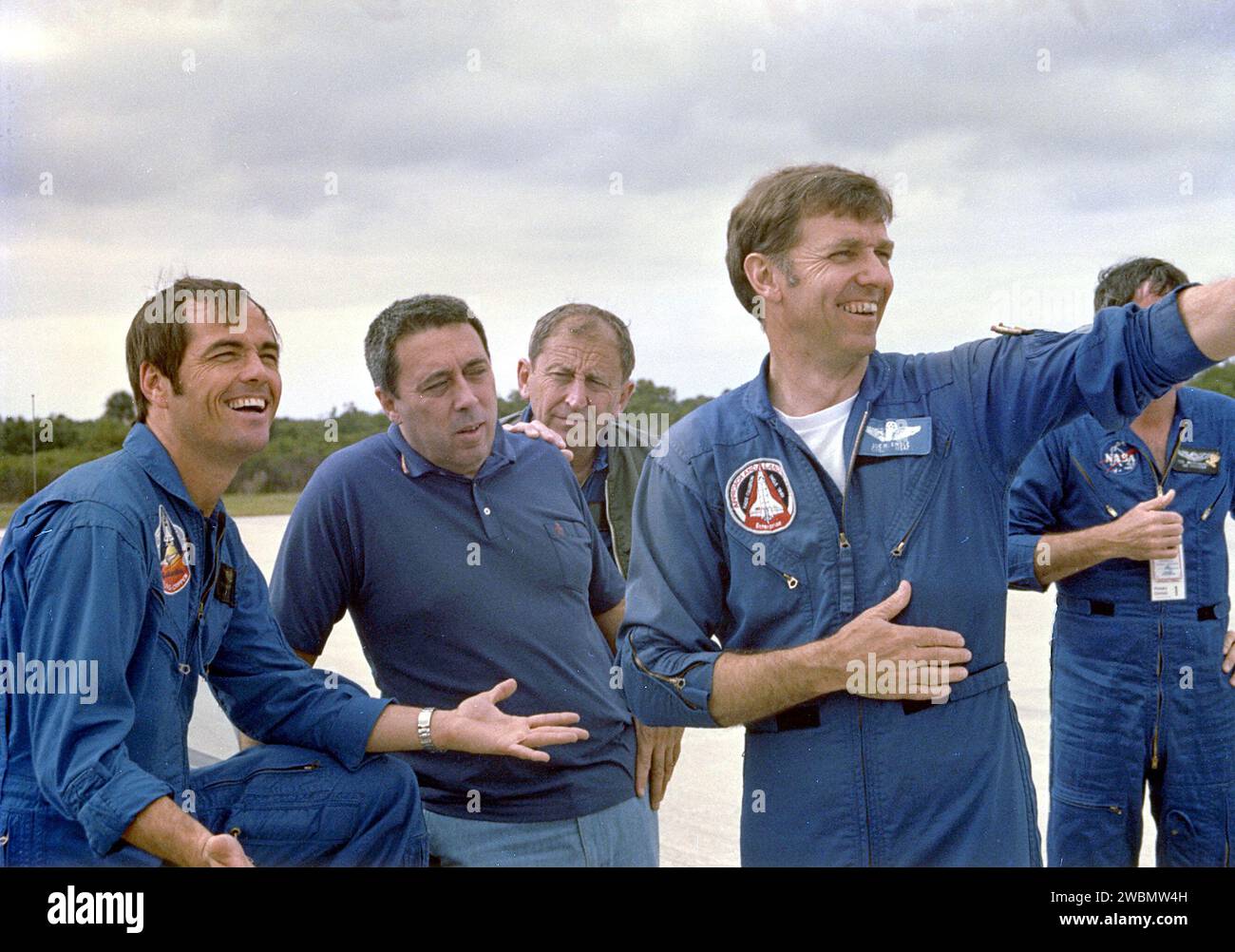 KENNEDY SPACE CENTER, FLA. - Astronaut Robert Crippen, left, relaxed despite the 'scrub' of the Space Shuttle launch on April 10, is joined at the Shuttle Landing Facility on April 11 by (from left) George Abbey, flight operations director; Joseph Algrantic, chief of Aircraft OPERATIONS Division, both with Johnson Space Center; and astronaut Joe Engle. Crippen and Young spent part of the day between the 'scrub' and the successful launch on April 12 in Shuttle landing practice, using a specially modified Grumman Airstream jet aircraft. Stock Photo