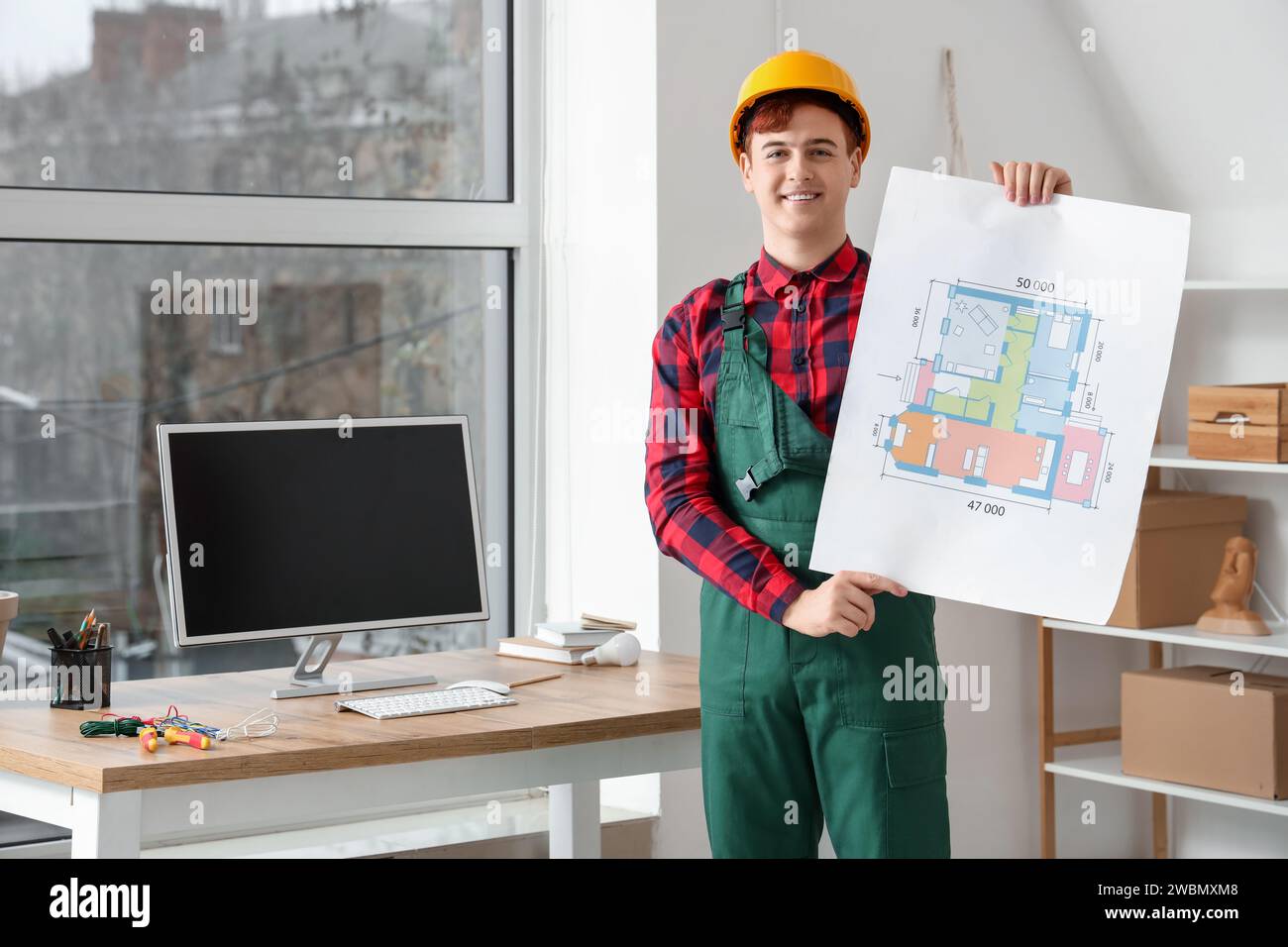 Male electrician with house plan in room Stock Photo