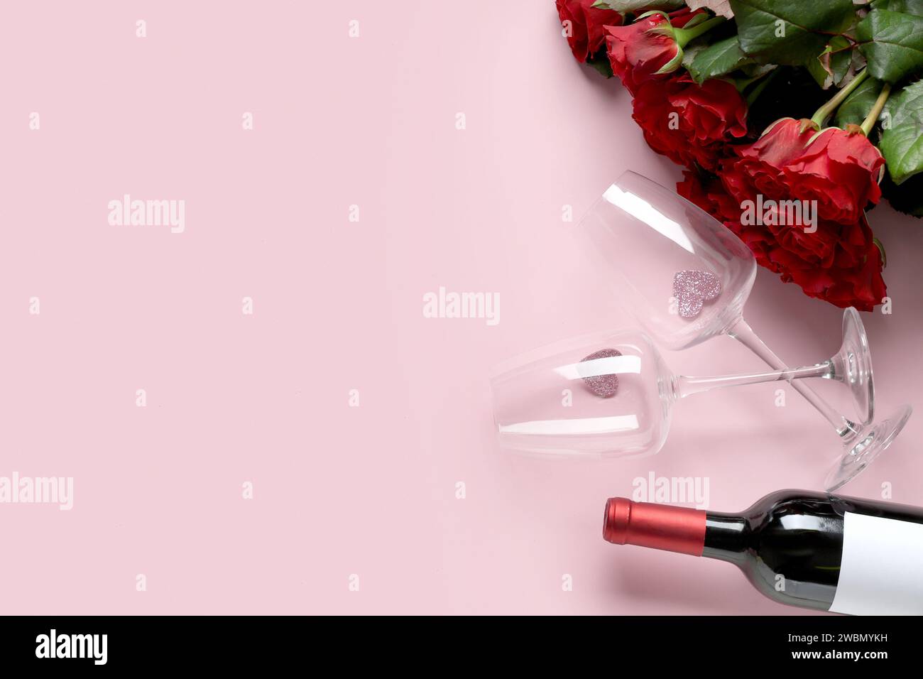 Bottle of wine with glasses and red roses on pink background. Valentine ...