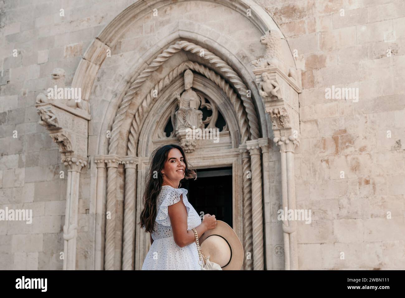 sachin and babi light blue dress An elegant young woman wearing a flowing white dress gracefully poses in  front of a majestic, historic church Stock Photo