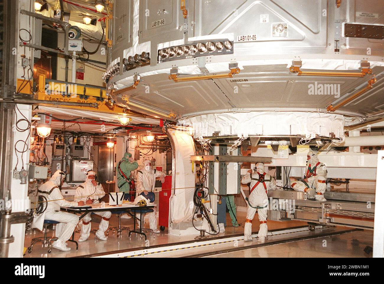Technicians in the Payload Changeout Room transfer the U.S. Laboratory ...
