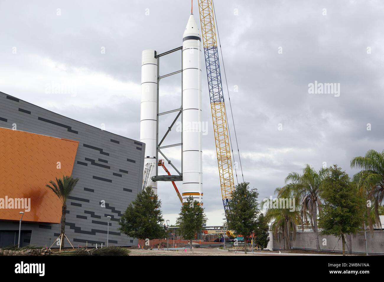 A crane installs the nose cone on a replica space shuttle solid rocket ...