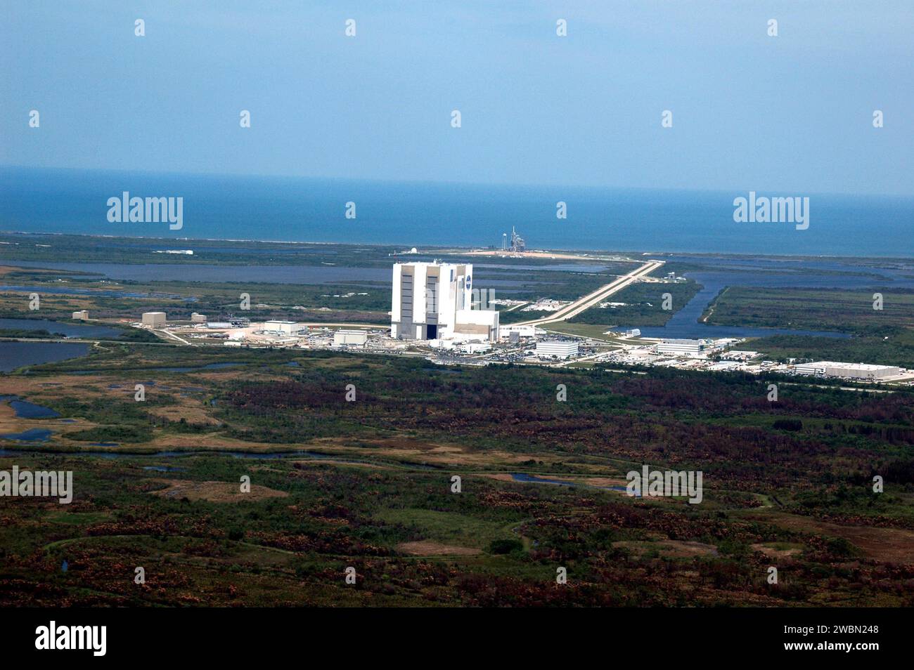 KENNEDY SPACE CENTER, FLA. - An aerial view of part of NASA's Kennedy Space Center giant complex featuring the Vehicle Assembly Building (VAB) and surrounding area. The Space Shuttle Discovery and its support stack of hardware, just a few days earlier, took the long, slow journey from the VAB atop the crawler transport vehicle to Launch Pad 39B in preparation for the STS-114 mission. The shuttle can be seen in the distant background, just above right center. This is one of a series of photos shot cross-cockpit from a NASA Gulfstream 2. Stock Photo