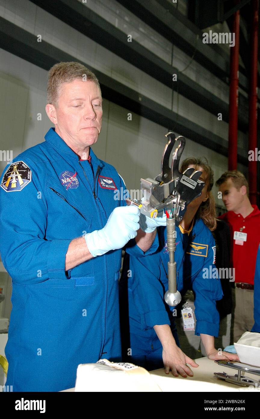KENNEDY SPACE CENTER, FLA. - In the Orbiter Processing Facility at NASA’s Kennedy Space Center, STS-121 Mission Specialist Michael E. Fossum practices using the Emergency Payload Door Closure Device. At right is Mission Specialist Lisa Nowak. STS-121 is the second Return to Flight mission. The crew is at KSC to participate in the Crew Equipment Interface Test (CEIT). During CEIT, the crew has an opportunity to get a hands-on look at the orbiter and equipment they will be working with on their missions. Mission STS-121 is scheduled to launch aboard Atlantis in July. Stock Photo