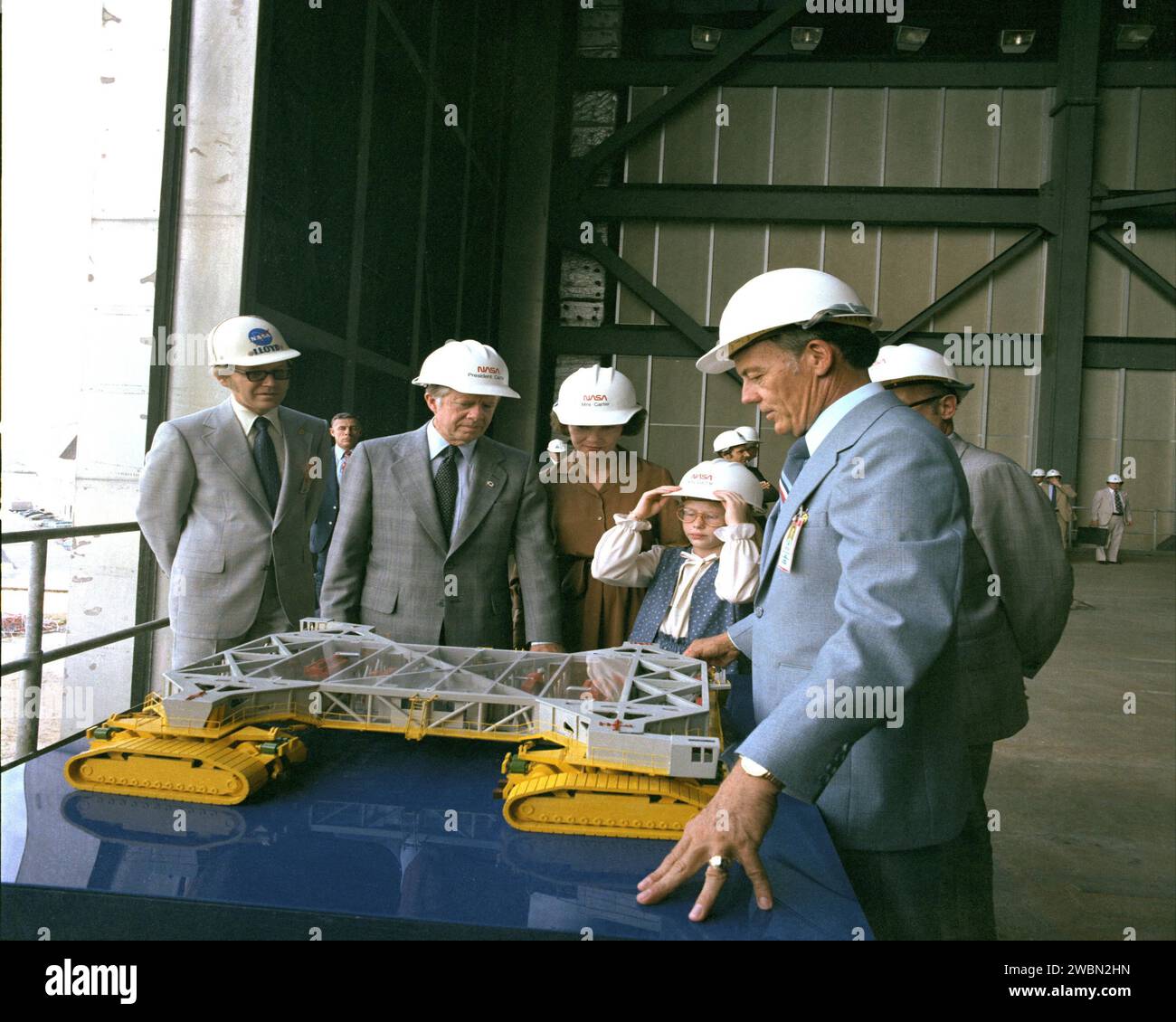 KENNEDY SPACE CENTER, FLA. -- President Jimmy Carter, with wife Rosalynn and daughter Amy, listen to Center Director Lee R. Scherer explain a model of the crawler transporter during their tour of the Kennedy Space Center. Stock Photo