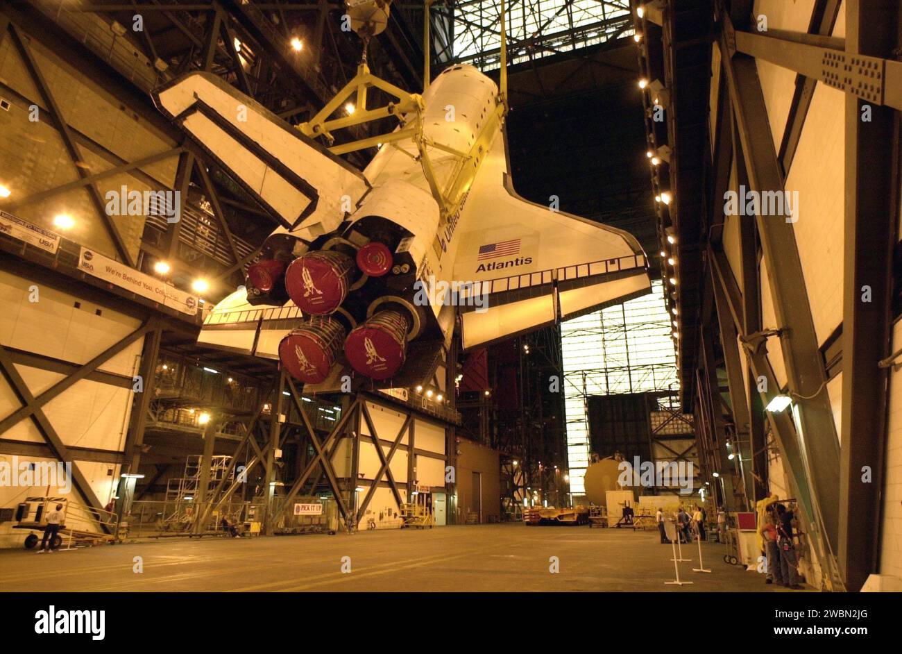 Orbiter Atlantis is raised vertically in the Vehicle Assembly Building ...