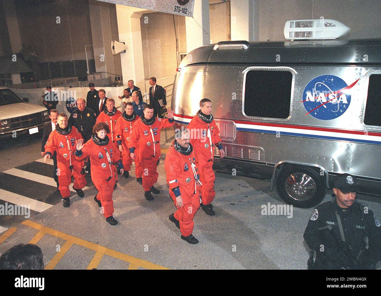 The STS-102 crew heads for the Astrovan after leaving the Operations and Checkout Building behind them. In front, left to right, are Mission Specialists James Voss, Susan Helms and Yury Usachev. In back, left to right, are Mission Specialists Andrew Thomas and Paul Richards, Pilot James Kelly and Commander James Wetherbee. STS-102 is the eighth construction flight to the Space Station, carrying the Multi-Purpose Logistics Module Leonardo. The primary delivery system used to resupply and return Station cargo requiring a pressurized environment, Leonardo will deliver up to 10 tons of laboratory Stock Photo
