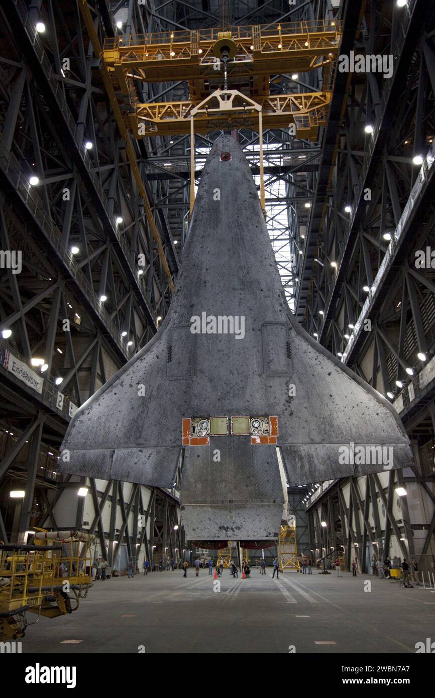 Shuttle Atlantis is suspended by an overhead crane in the Vehicle ...