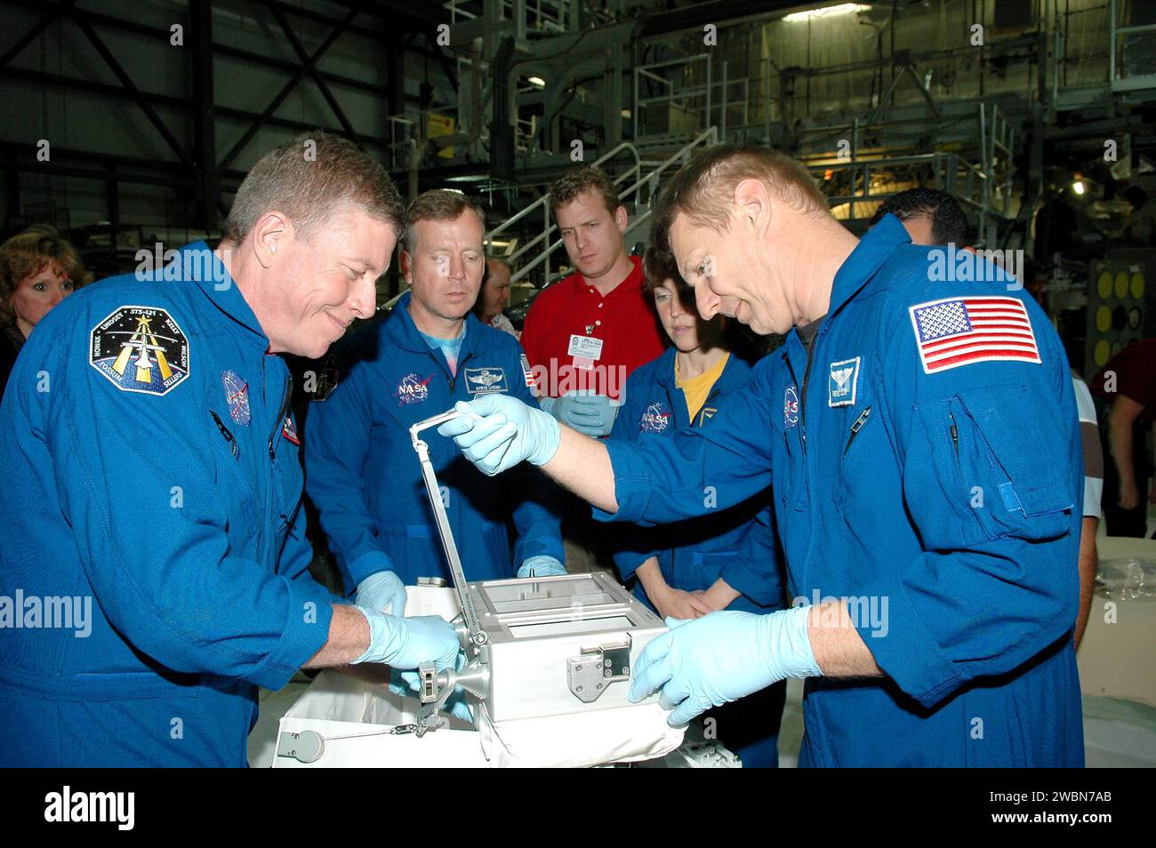 KENNEDY SPACE CENTER, FLA. - In the Orbiter Processing Facility at NASA’s Kennedy Space Center, astronauts of the second Return to Flight mission, STS-121, practice using the Tile Repair Kit. Crew members seen in this photo are, left to right, Mission Specialist Michael E. Fossum, Commander Steven W. Lindsey, and Mission Specialists Lisa Nowak and Piers J. Sellers. The crew is at KSC to participate in the Crew Equipment Interface Test (CEIT). During CEIT, the crew has an opportunity to get a hands-on look at the orbiter and equipment they will be working with on their missions. Mission STS-121 Stock Photo