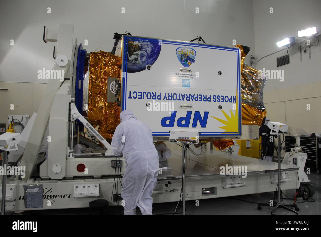 In a clean room inside the Astrotech Payload Processing Facility at Vandenberg Air Force Base in California, a Ball Aerospace technician positions NASA’s National Polar-orbiting Operational Environmental Satellite System Preparatory Project (NPP) before testing. NPP represents a critical first step in building the next-generation of Earth-observing satellites. NPP will carry the first of the new sensors developed for this satellite fleet, now known as the Joint Polar Satellite System (JPSS), to be launched in 2016. NPP is the bridge between NASA's Earth Observing System (EOS) satellites and th Stock Photo