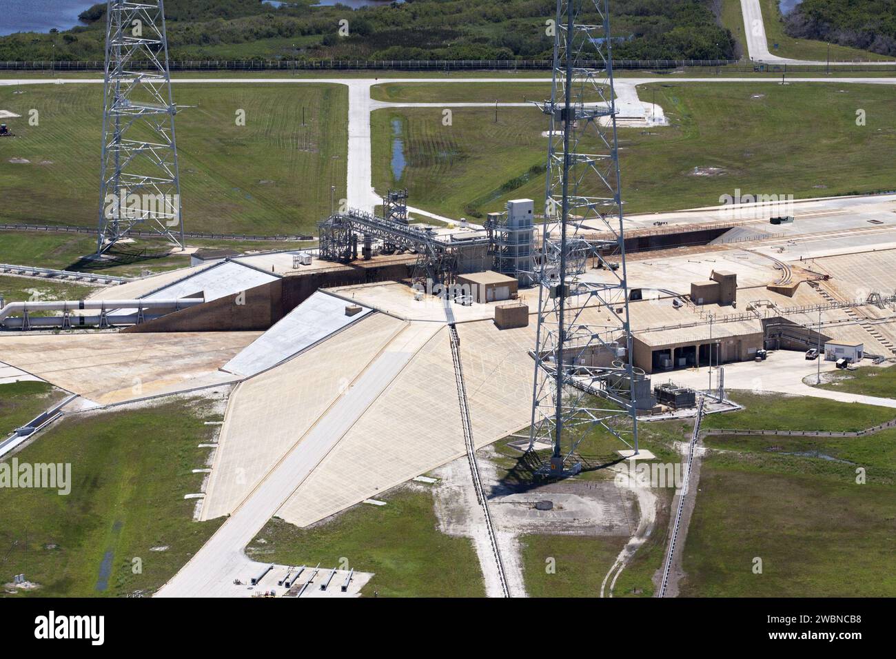 CAPE CANAVERAL, Fla. – An aerial view shows construction progress at Launch Pad 39B at NASA’s Kennedy Space Center in Florida. A new elevator has been constructed on the surface of the pad and the crawlerway leading up to the surface is being repaired. Repairs also are being made to the crawler track panels and catacomb roof below on either side of the flame trench. Also in view are two of the three tall lightning towers that surround the pad. Upgrades are underway at Pad B and other facilities in the Launch Complex 39 area. The Ground Systems Development and Operations, or GSDO, Program offic Stock Photo