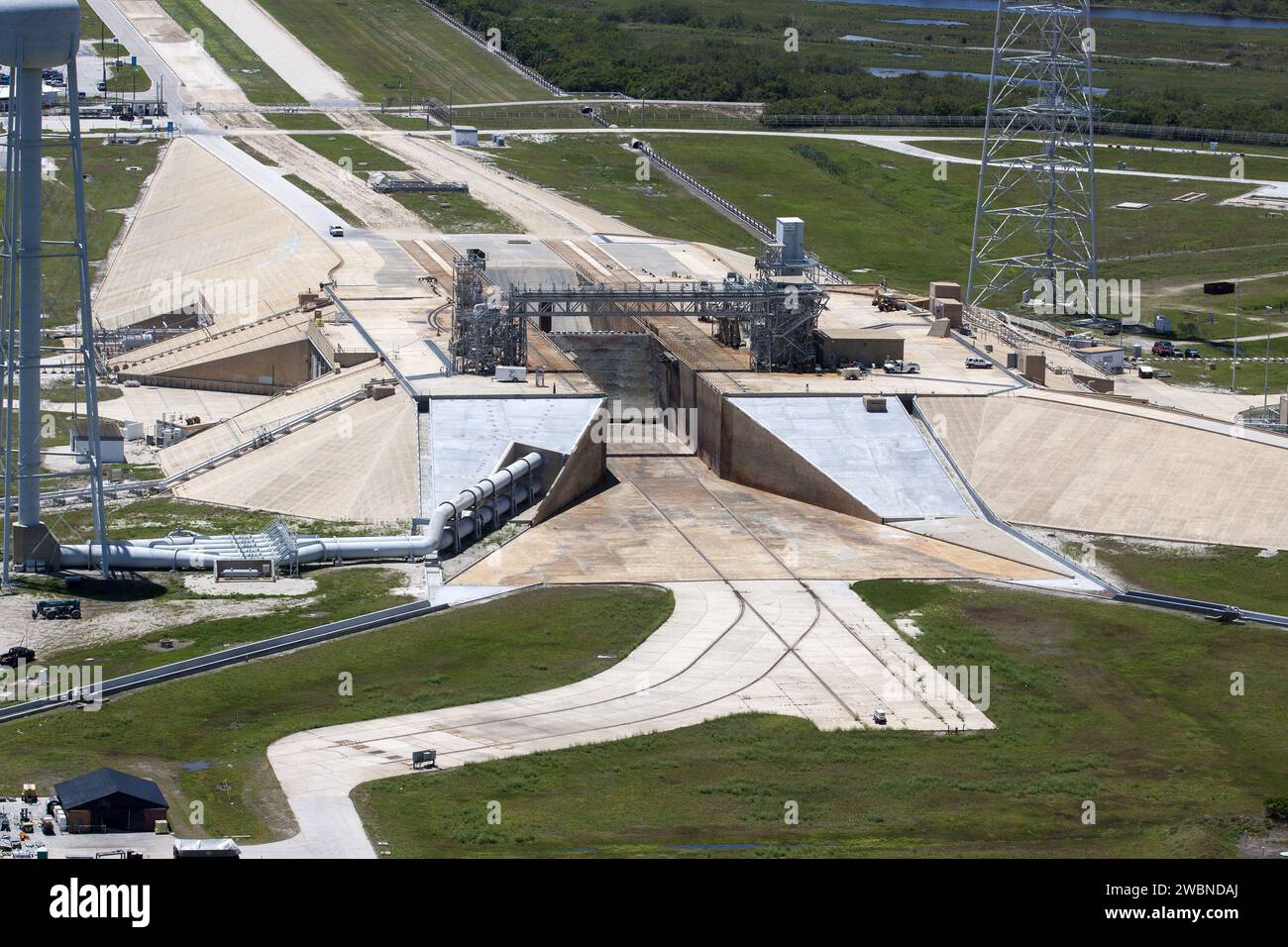 CAPE CANAVERAL, Fla. – An aerial view shows construction progress at Launch Pad 39B at NASA’s Kennedy Space Center in Florida. A new elevator has been constructed on the surface of the pad and the crawlerway leading up to the surface is being repaired. Repairs also are being made to the crawler track panels and catacomb roof below on either side of the flame trench. To the right is one of three tall lightning towers. Upgrades are underway at Pad B and other facilities in the Launch Complex 39 area. The Ground Systems Development and Operations, or GSDO, Program office at Kennedy is leading the Stock Photo