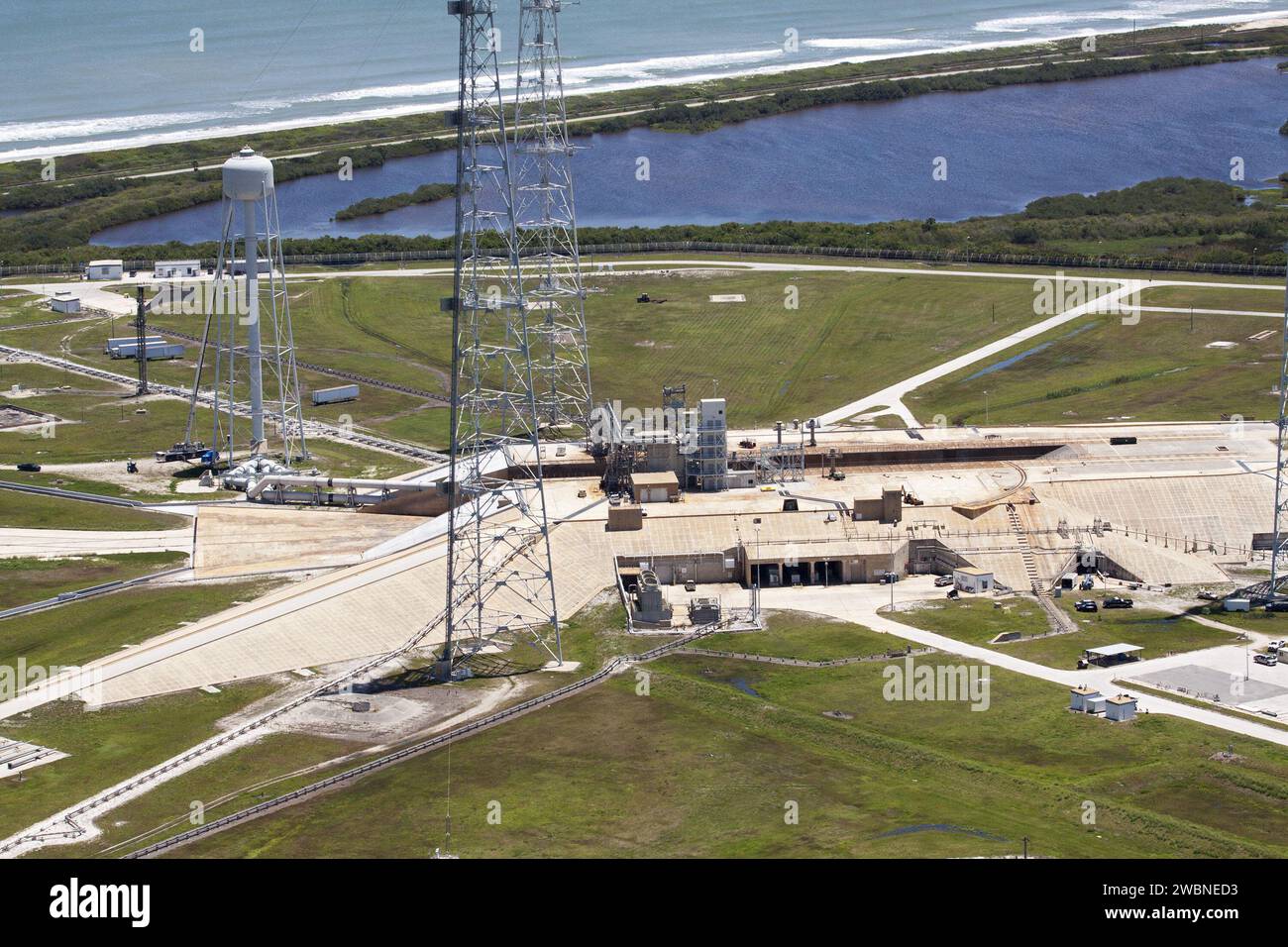 CAPE CANAVERAL, Fla. – An aerial view shows construction progress at Launch Pad 39B at NASA’s Kennedy Space Center in Florida. A new elevator has been constructed on the surface of the pad and the crawlerway leading up to the surface is being repaired. Repairs also are being made to the crawler track panels and catacomb roof below on either side of the flame trench. Also in view are the water tower and two of the three tall lightning towers that surround the pad. Upgrades are underway at Pad B and other facilities in the Launch Complex 39 area. The Ground Systems Development and Operations, or Stock Photo
