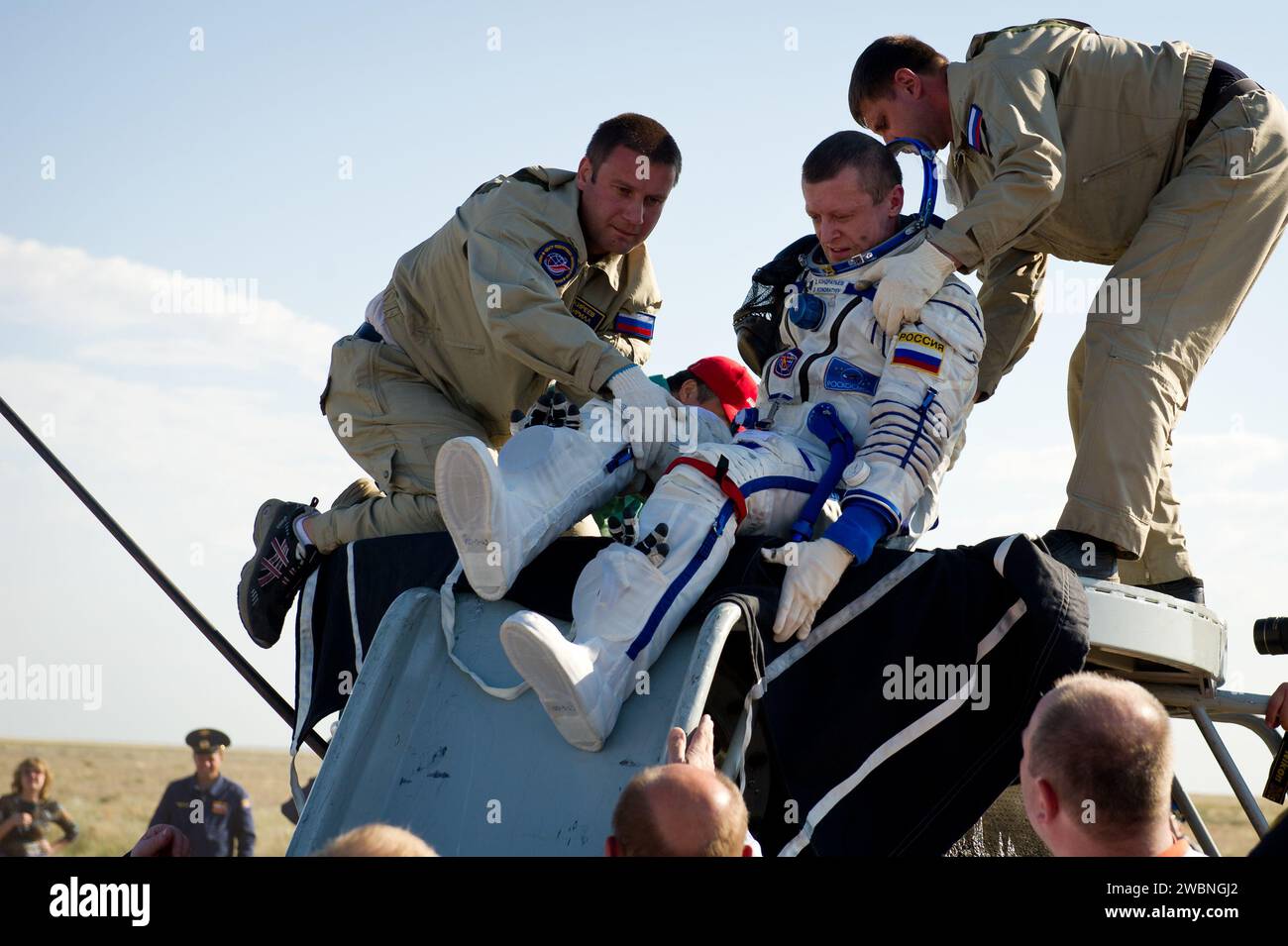 Expedition 27 Commander Dmitry Kondratyev is helped out of the Spyuz TMA-20 spacecraft shortly after he and Flight Engineers Cady Coleman and Paolo Nespoli landed southeast of the town of Zhezkazgan, Kazakhstan, on Tuesday, May 24, 2011.  NASA Astronaut Coleman, Russian Cosmonaut Kondratyev and Italian Astronaut Nespoli are returning from more than five months onboard the International Space Station where they served as members of the Expedition 26 and 27 crews. Stock Photo