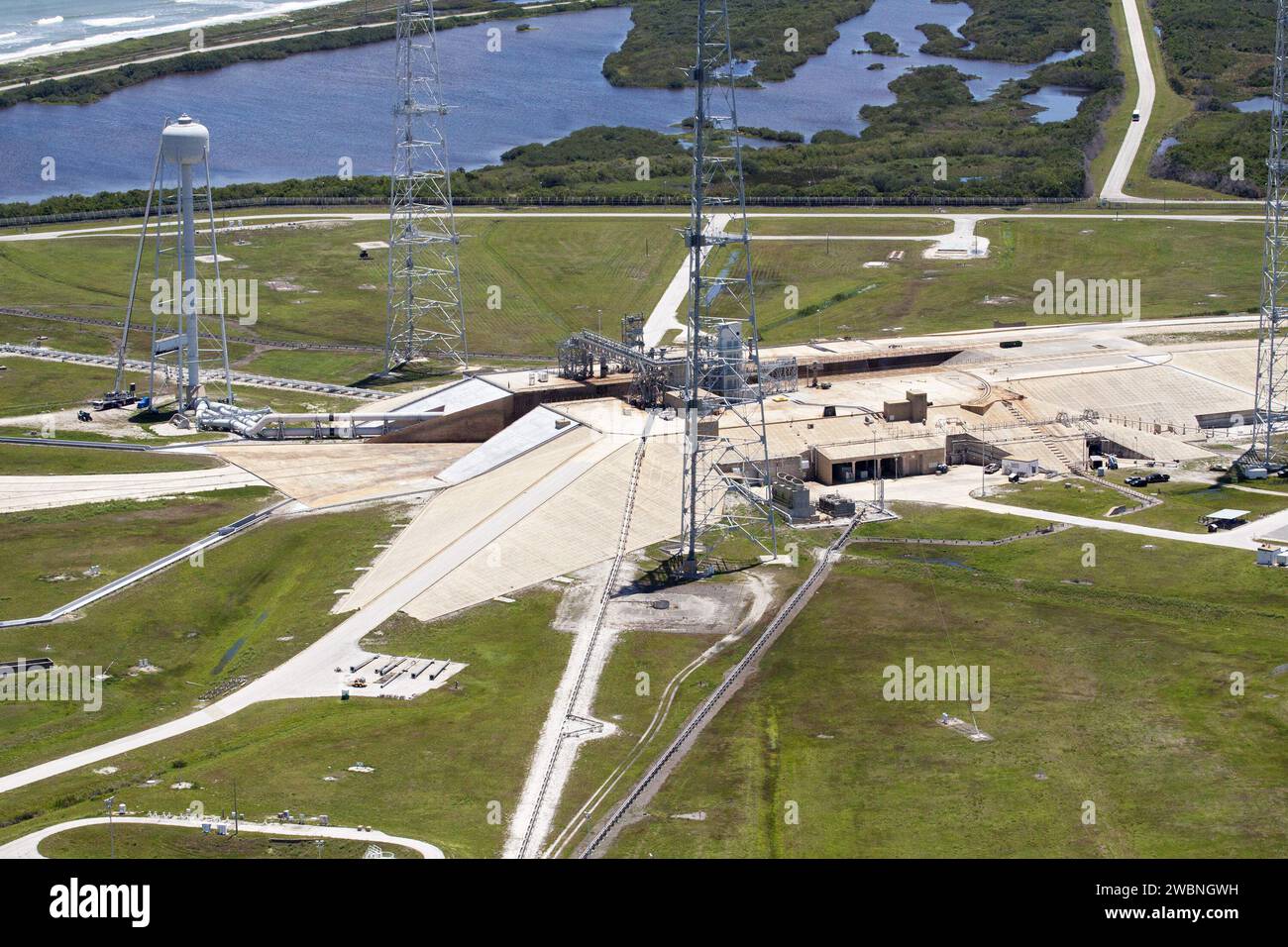CAPE CANAVERAL, Fla. – An aerial view shows construction progress at Launch Pad 39B at NASA’s Kennedy Space Center in Florida. A new elevator has been constructed on the surface of the pad and the crawlerway leading up to the surface is being repaired. Repairs also are being made to the crawler track panels and catacomb roof below on either side of the flame trench. Also in view are the water tower and two of the three tall lightning towers that surround the pad. Upgrades are underway at Pad B and other facilities in the Launch Complex 39 area. The Ground Systems Development and Operations, or Stock Photo