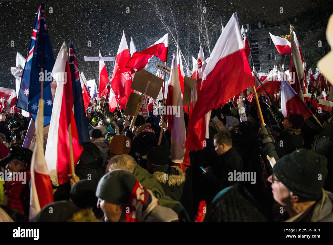 Thousands of protesters wave Polish flags and hold placards during the demonstration. Poland's right-wing opposition, frustrated over its recent loss of power, urged its supporters to protest against moves by the new pro-European Union government to take control of state broadcasters and the state news agency. The Law and Justice party (PiS), which governed for eight years before losing October's parliamentary elections, called for a protest under the slogan “Protest of Free Poles” (Protest Wolnych Polakow) outside parliament. It portrayed the protest as a defense of democracy and free media, Stock Photo