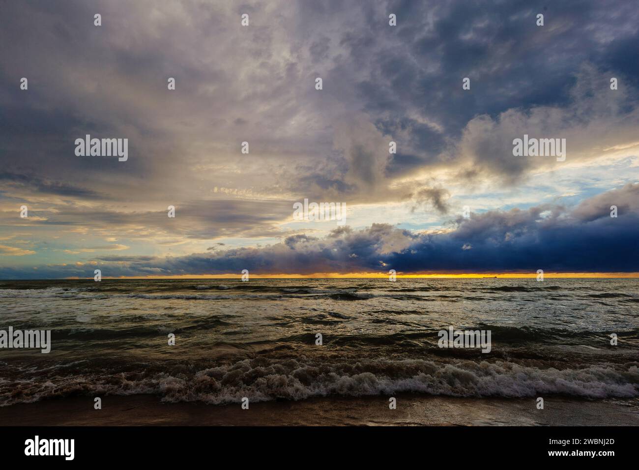Sunset or dawn on sea. Dramatic cloudy sky. Stock Photo
