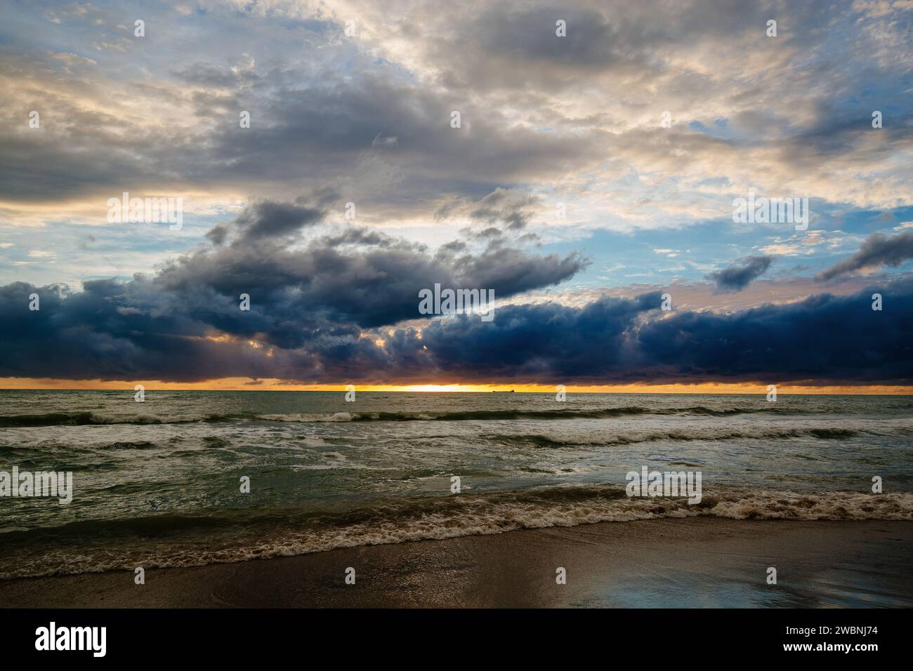Sunset or dawn on sea. Dramatic cloudy sky. Stock Photo