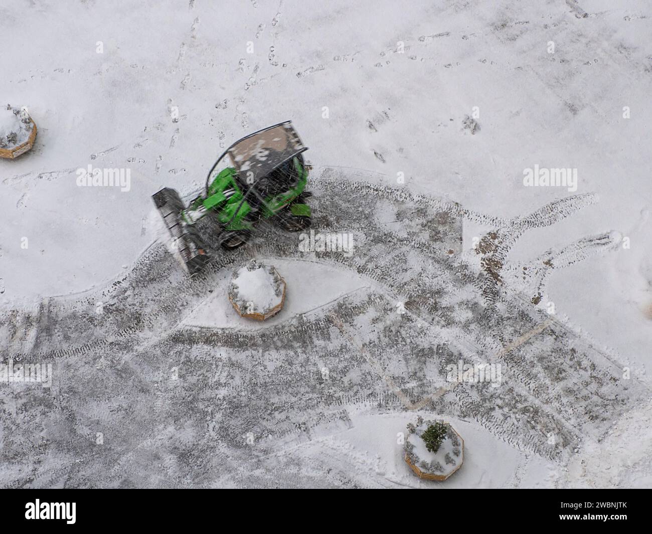 The small snowplow cleans and removes snow from a house yard and ...