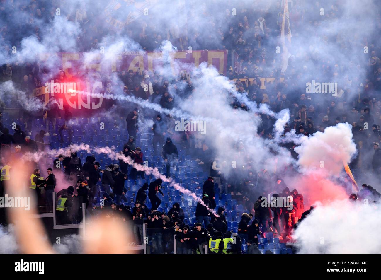 Lazio and Roma fans throw flares and smoke grenades each other during